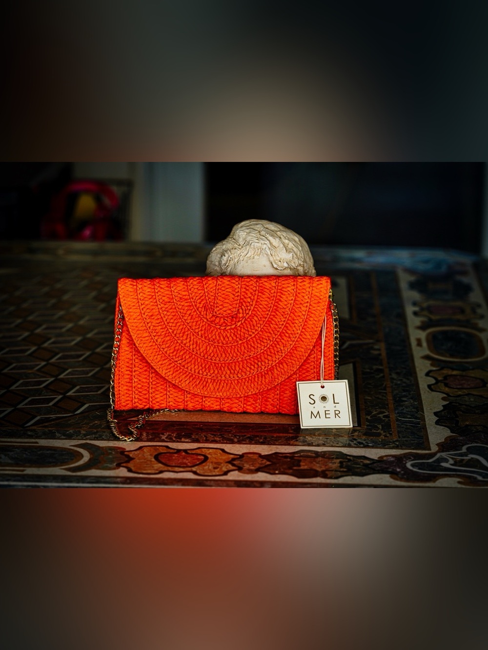 SOL and MER woven straw envelope clutch in bright tangerine orange.